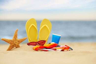 Photo of Different beach objects on sand near sea