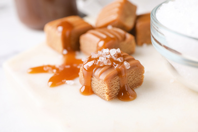 Salted caramel with sauce on white board, closeup view