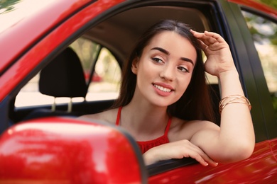 Photo of Happy young beautiful woman in modern car