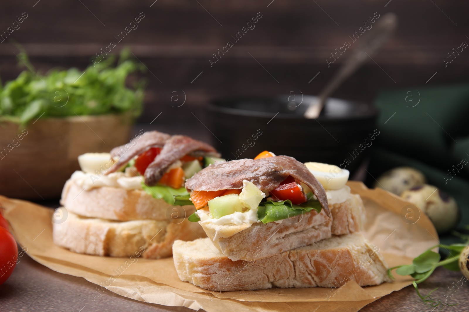 Photo of Delicious bruschettas with anchovies, eggs, cream cheese, tomatoes, bell peppers and cucumbers on grey table, space for text