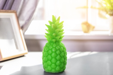 Photo of Pineapple shaped candle on table in room