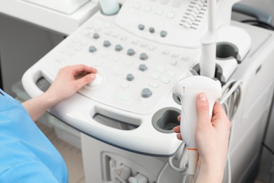 Sonographer operating modern ultrasound machine in clinic, closeup