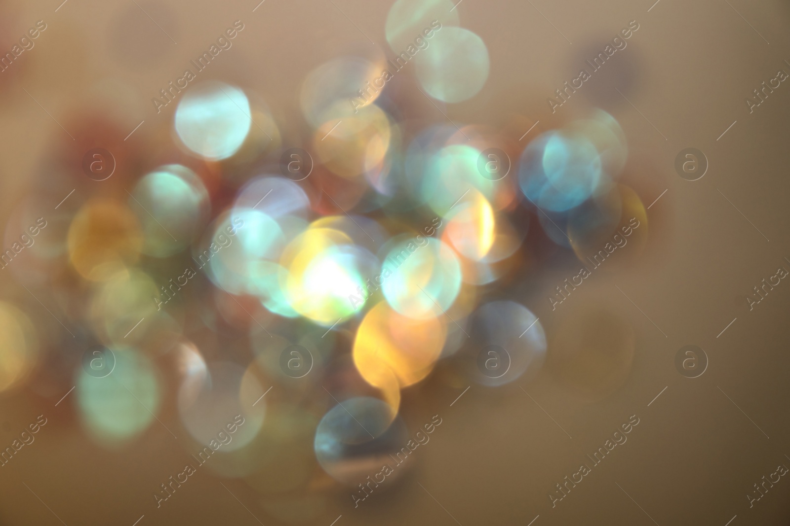 Photo of Blurred view of shiny lights on beige background. Bokeh effect