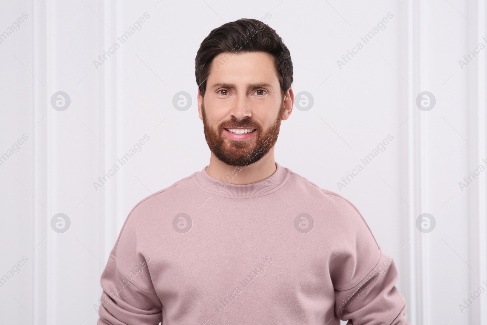 Photo of Portrait of handsome man near white wall