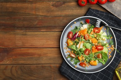 Photo of Delicious salad with lentils and vegetables served on wooden table, flat lay. Space for text