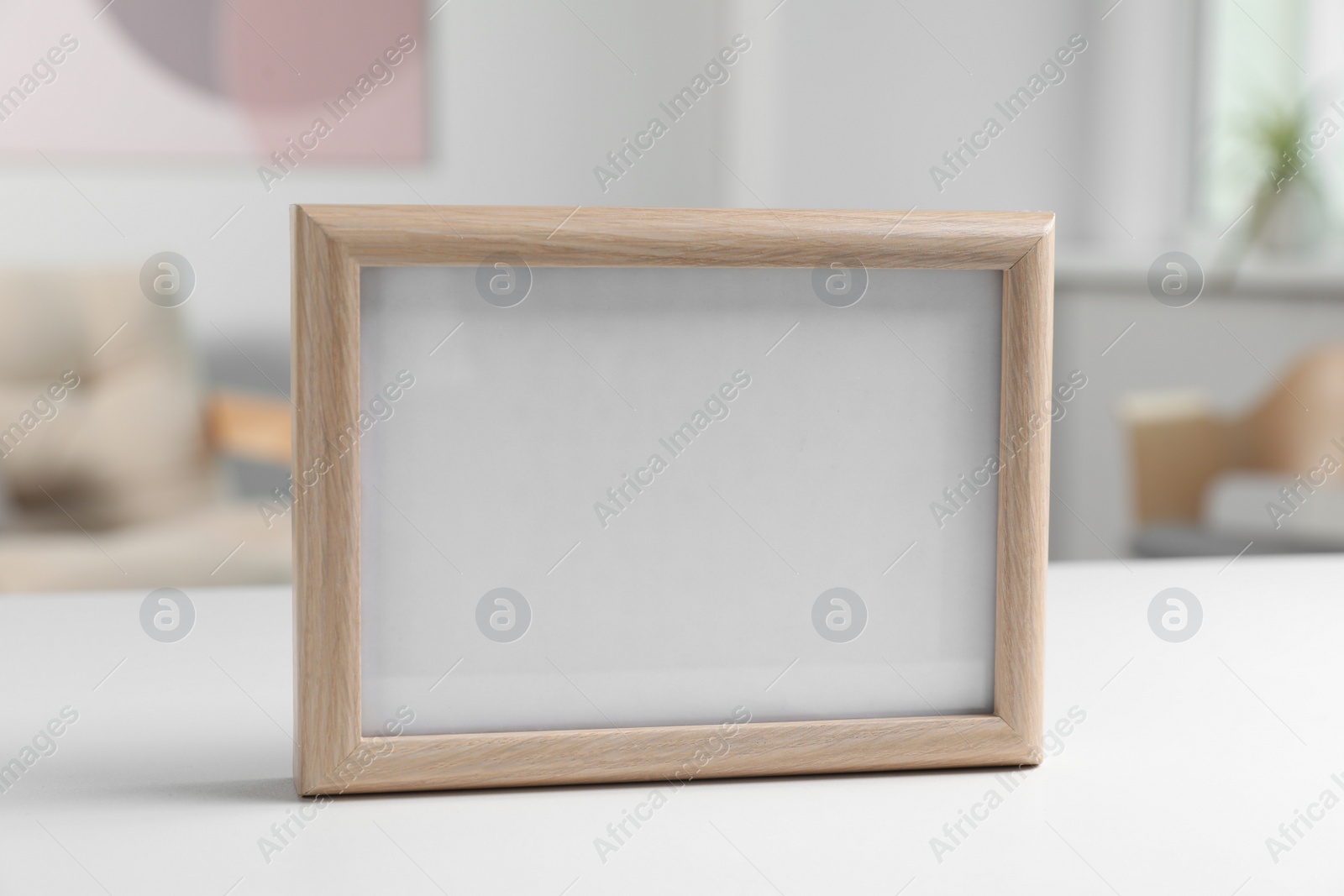 Photo of Blank board on white table in living room. Space for text