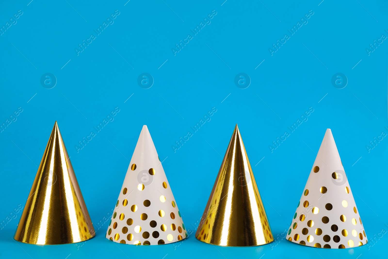 Photo of Colorful party hats on light blue background