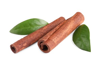 Photo of Cinnamon sticks and green leaves isolated on white