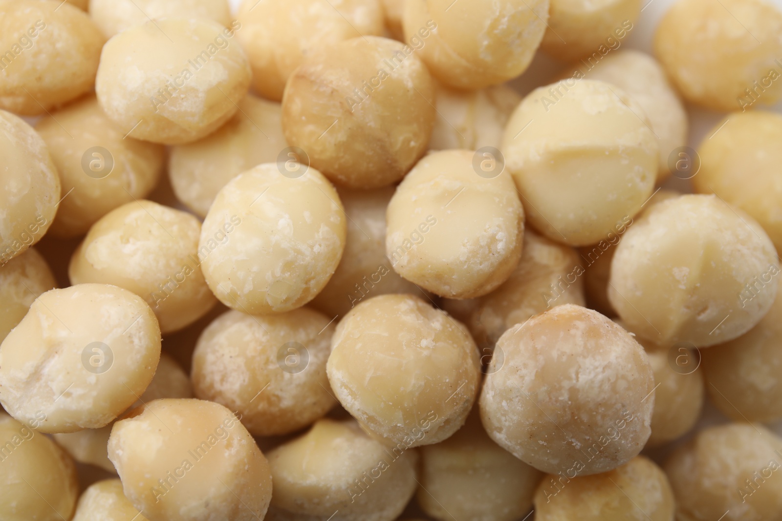 Photo of Tasty peeled Macadamia nuts as background, top view