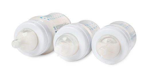 Photo of Three feeding bottles with infant formula on white background