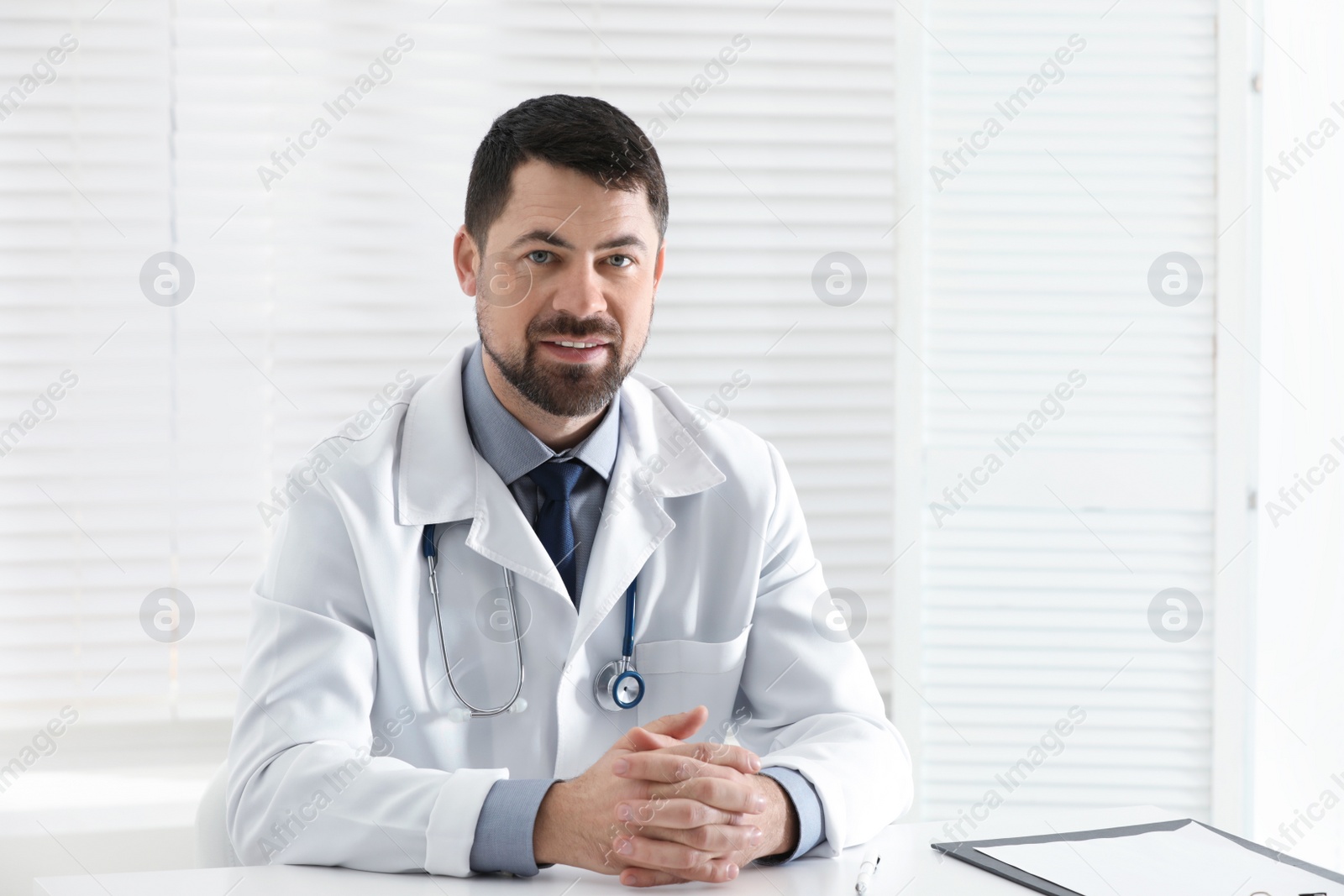 Photo of Portrait of male doctor in white coat at workplace