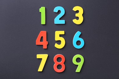 Photo of Colorful numbers on black background, flat lay