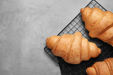 Tasty fresh croissants on light grey table, flat lay. Space for text