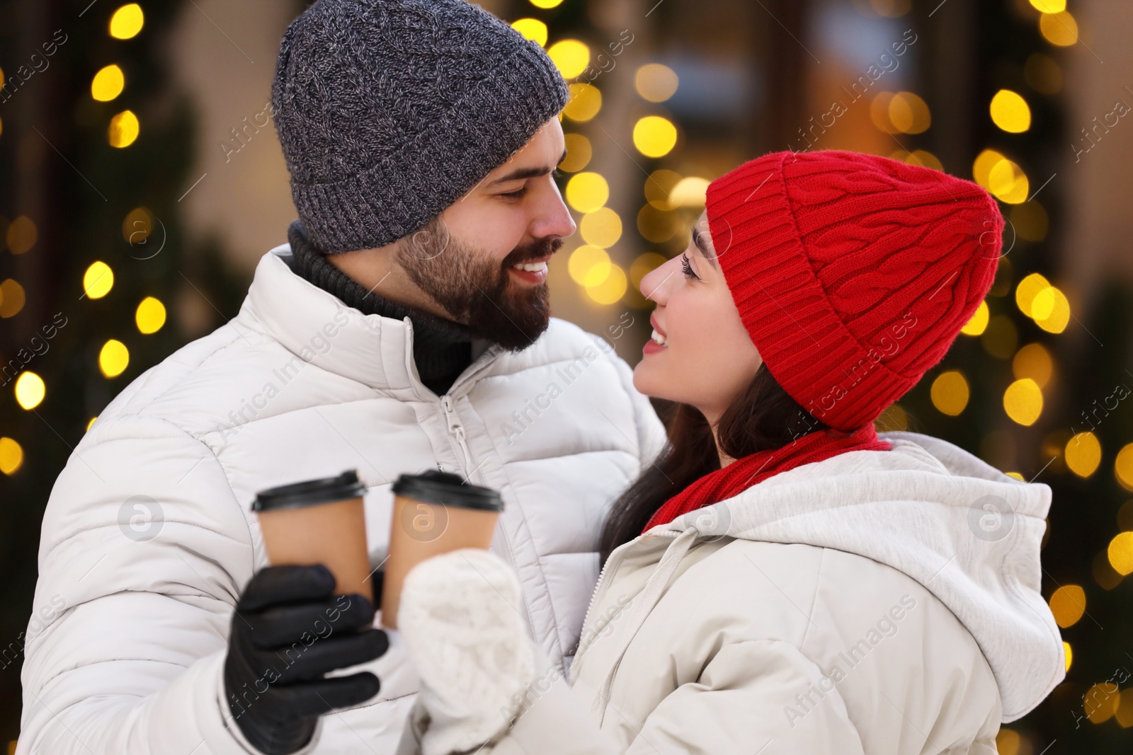 Photo of Lovely couple with hot drinks spending time together outdoors