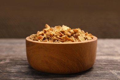Bowl of dried orange zest seasoning on wooden table