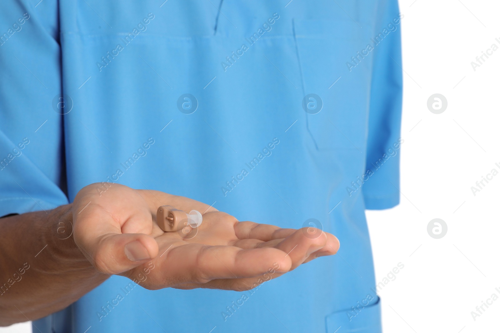 Photo of Male doctor holding hearing aid on white background, closeup. Medical object