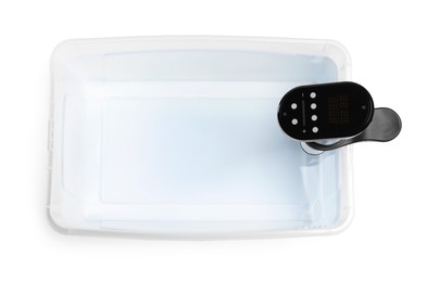 Photo of Thermal immersion circulator in plastic container with water isolated on white, top view. Sous vide cooker