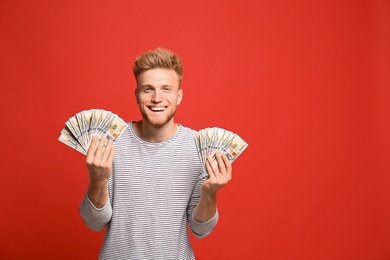 Photo of Portrait of happy lottery winner with money on red background