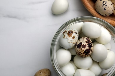 Unpeeled and peeled boiled quail eggs on white table, flat lay. Space for text