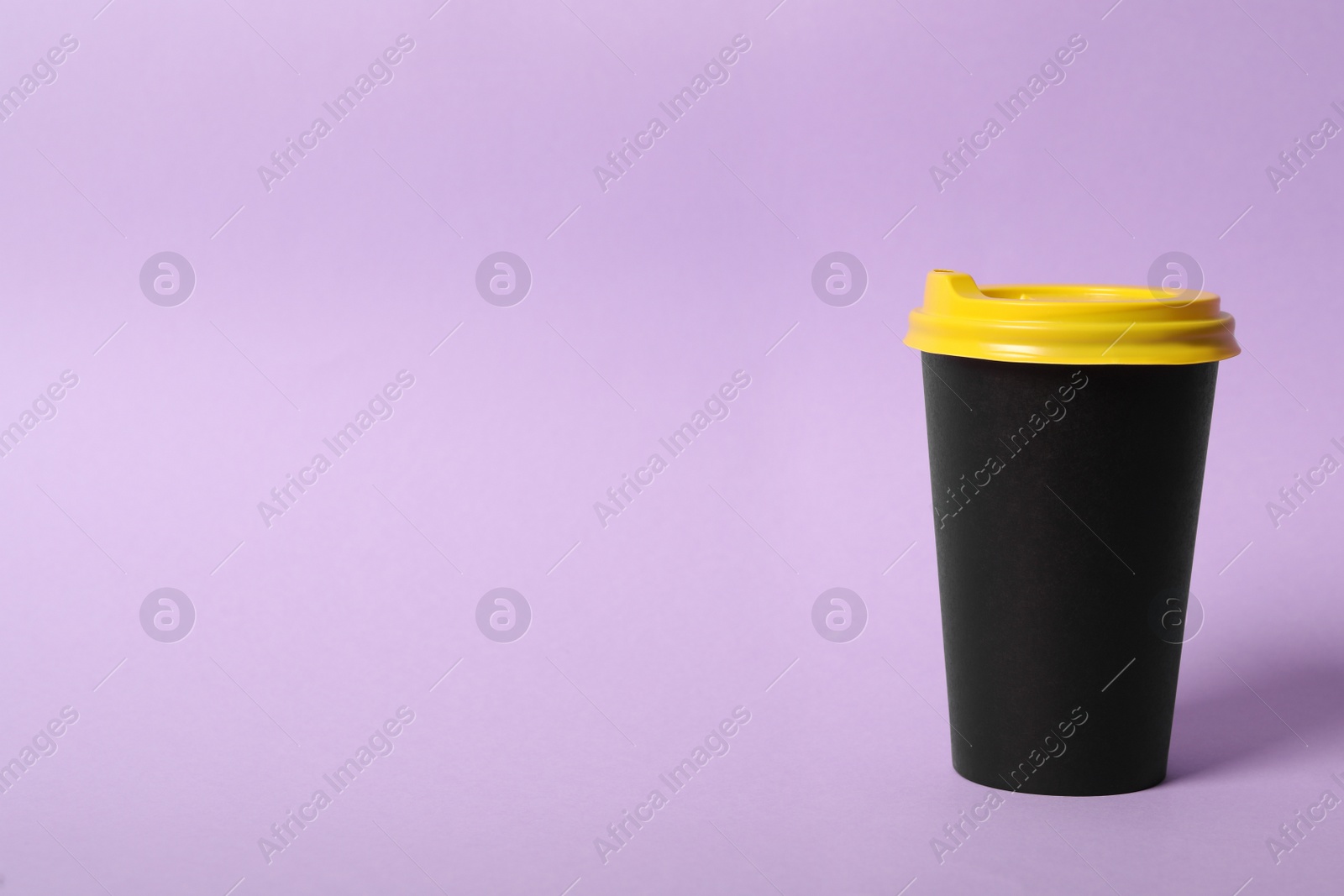 Photo of Takeaway paper coffee cup on violet background. Space for text