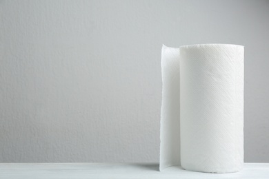 Roll of paper towels on white wooden table, space for text