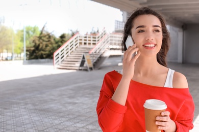 Photo of Young woman talking on mobile phone outdoors