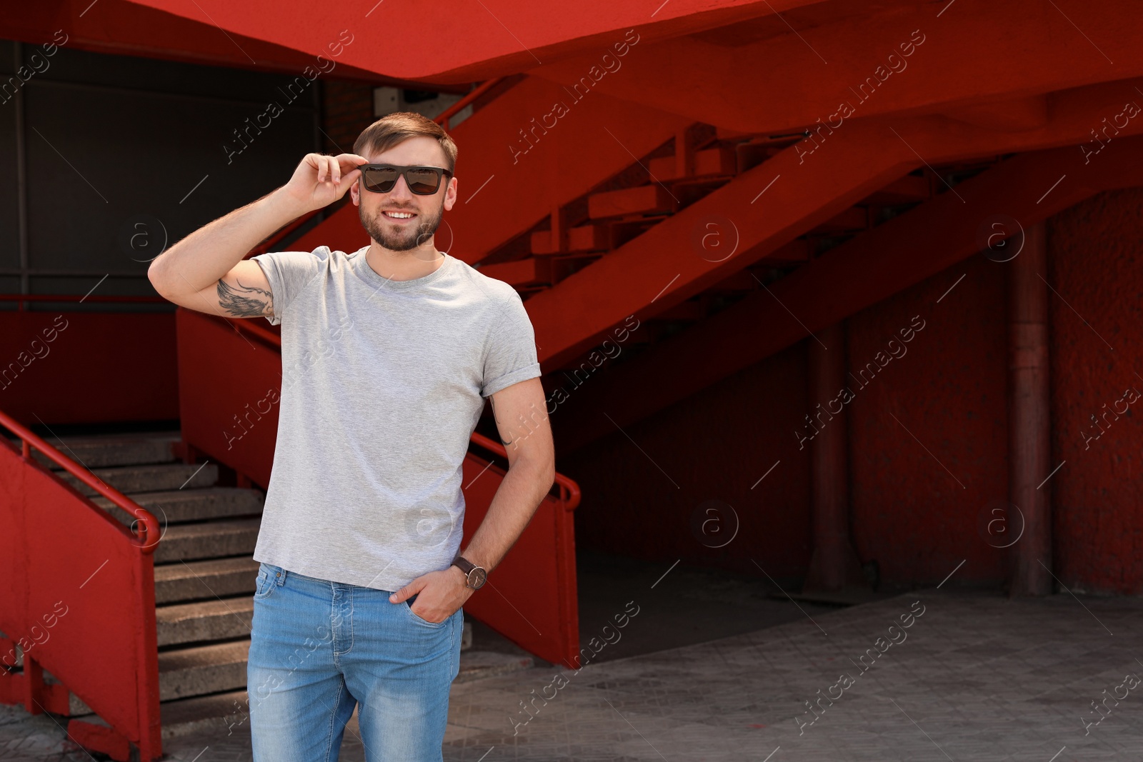 Photo of Young man wearing gray t-shirt on street. Urban style