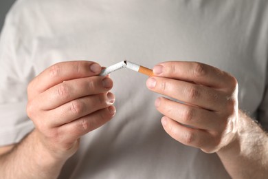 Photo of Stop smoking concept. Man breaking cigarette, closeup