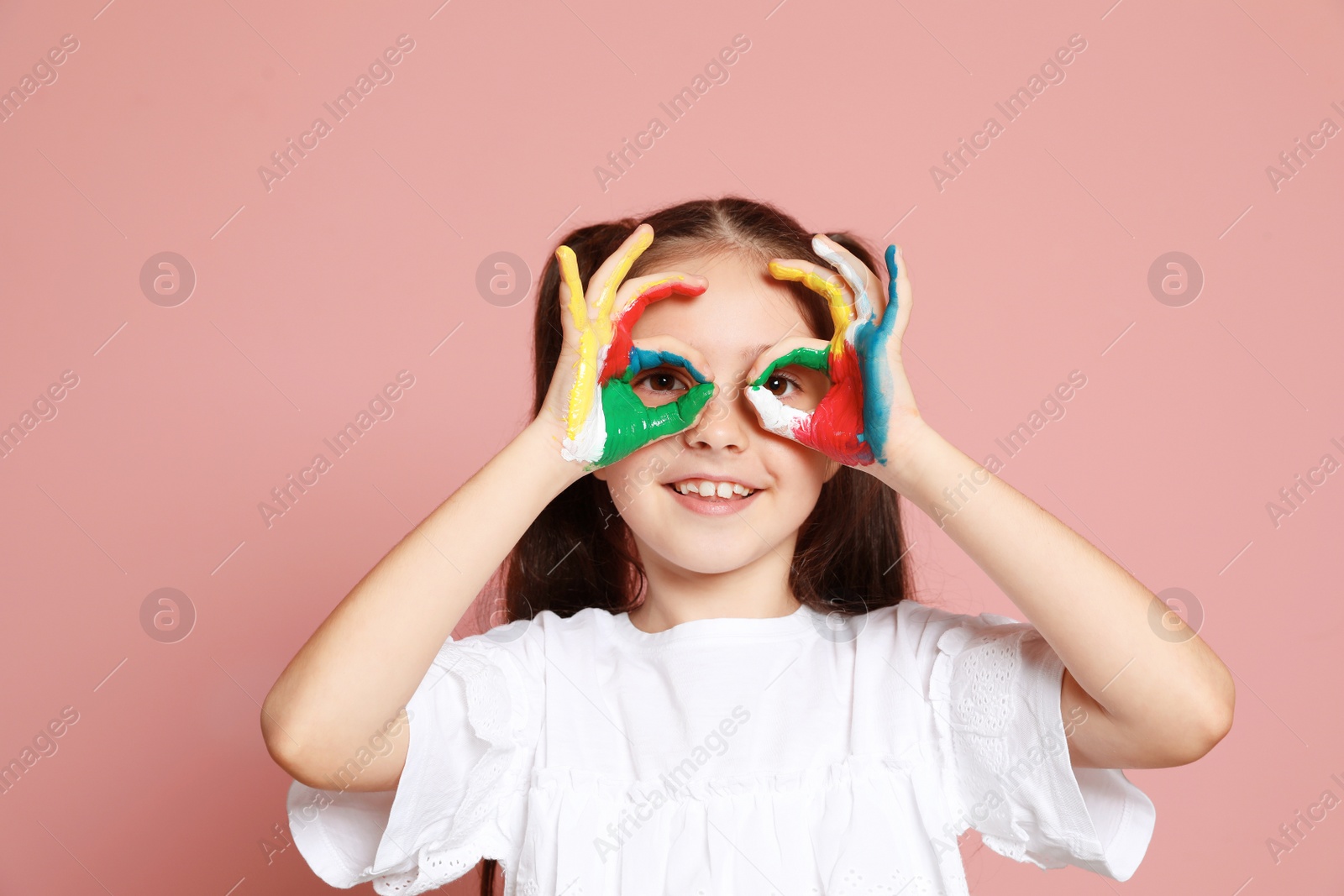 Photo of Little child with painted hands on color background