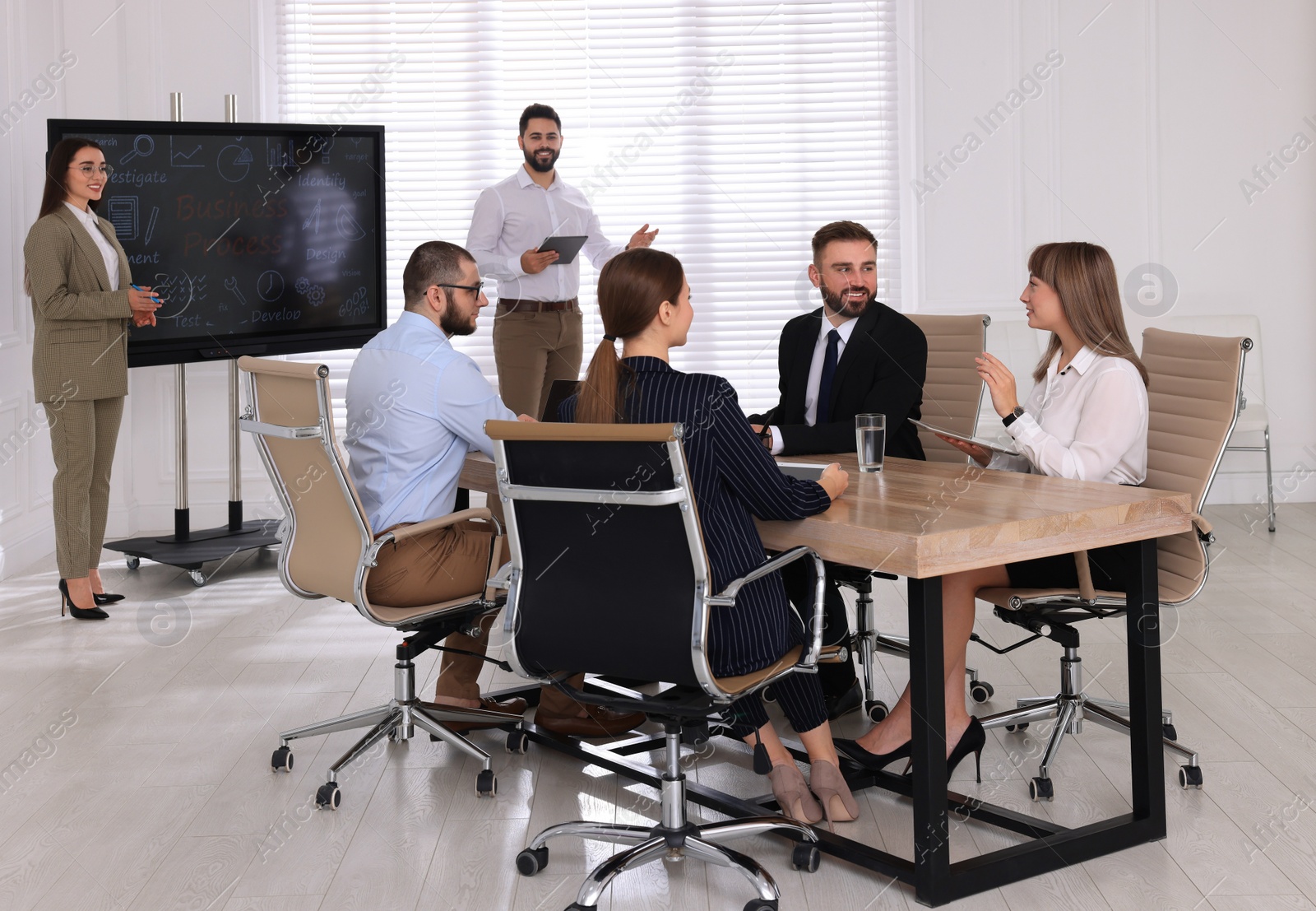 Photo of Business training. People in meeting room with interactive board
