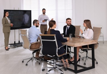 Photo of Business training. People in meeting room with interactive board