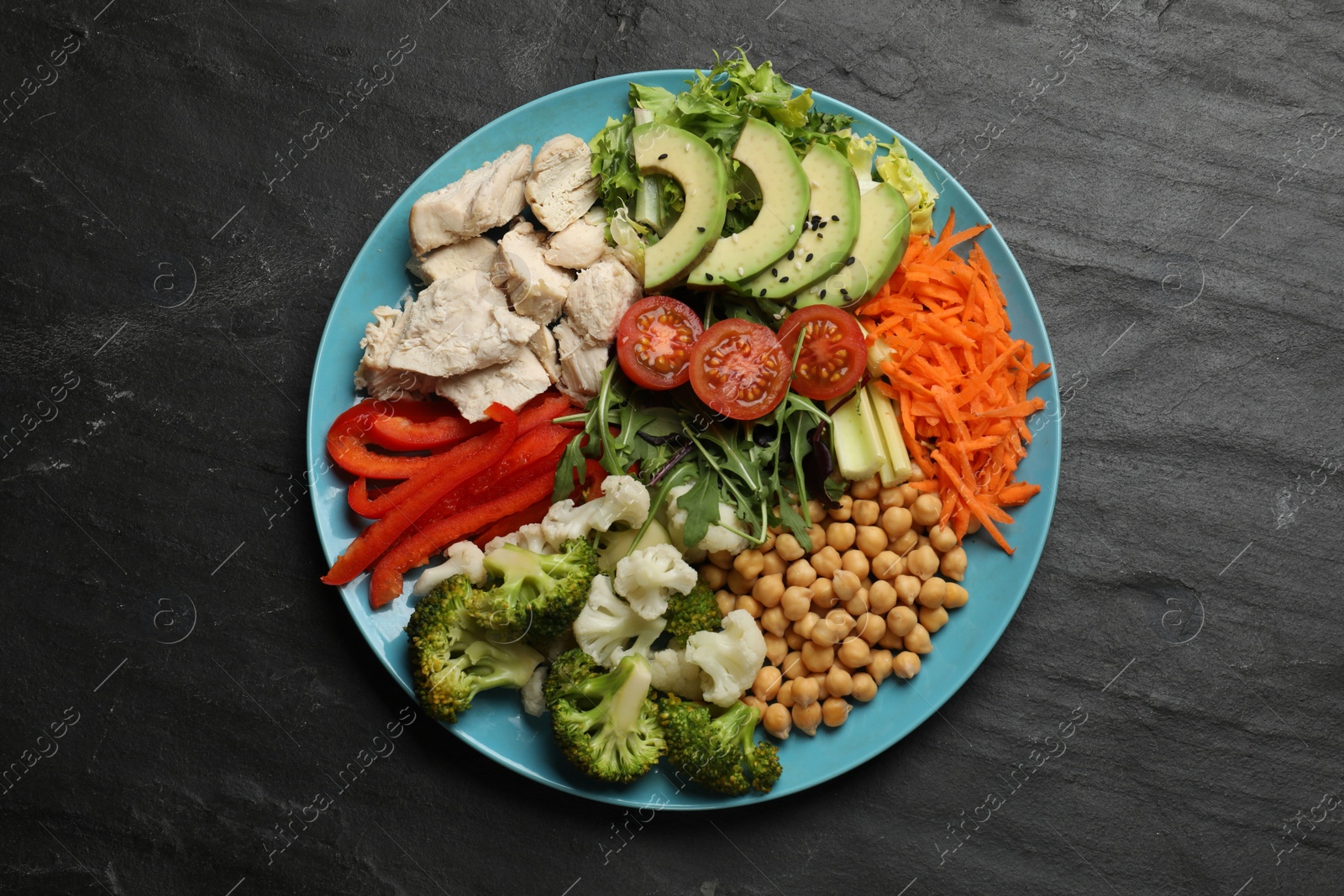 Photo of Balanced diet and healthy foods. Plate with different delicious products on black table, top view