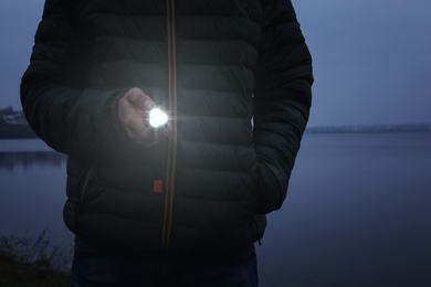 Photo of Man with flashlight walking outdoors, closeup view