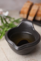 Photo of Saucepan of organic balsamic vinegar with oil on light grey table, closeup