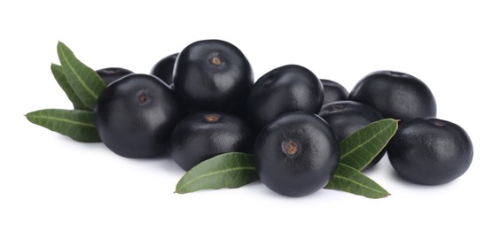 Pile of fresh ripe acai berries and green leaves on white background