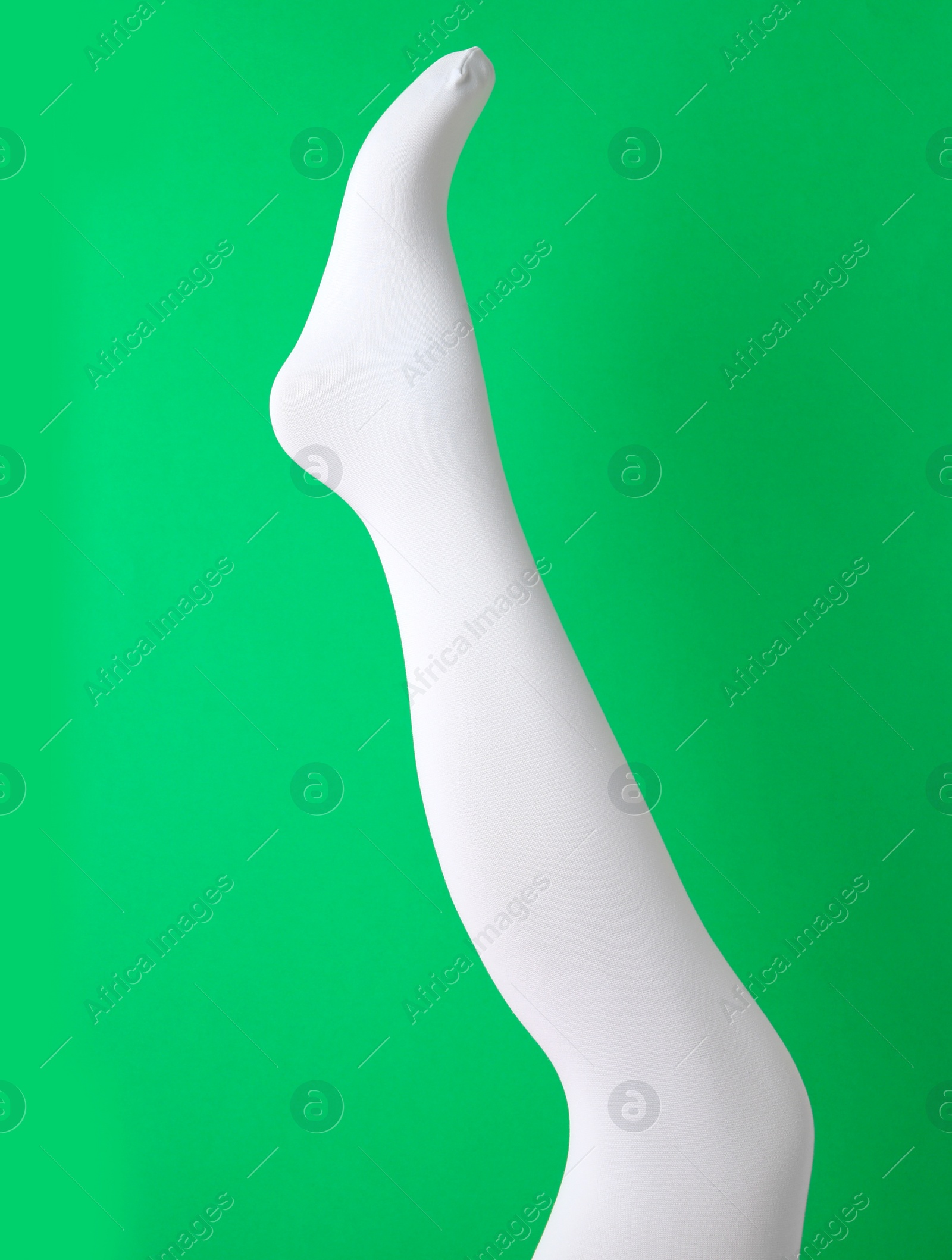 Photo of Leg mannequin in white tights on green background