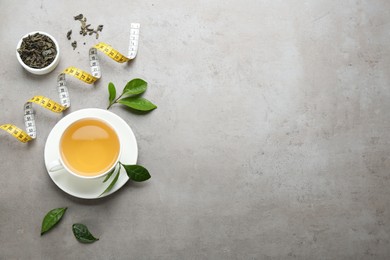 Photo of Flat lay composition with herbal diet tea and measuring tape on light table. Space for text