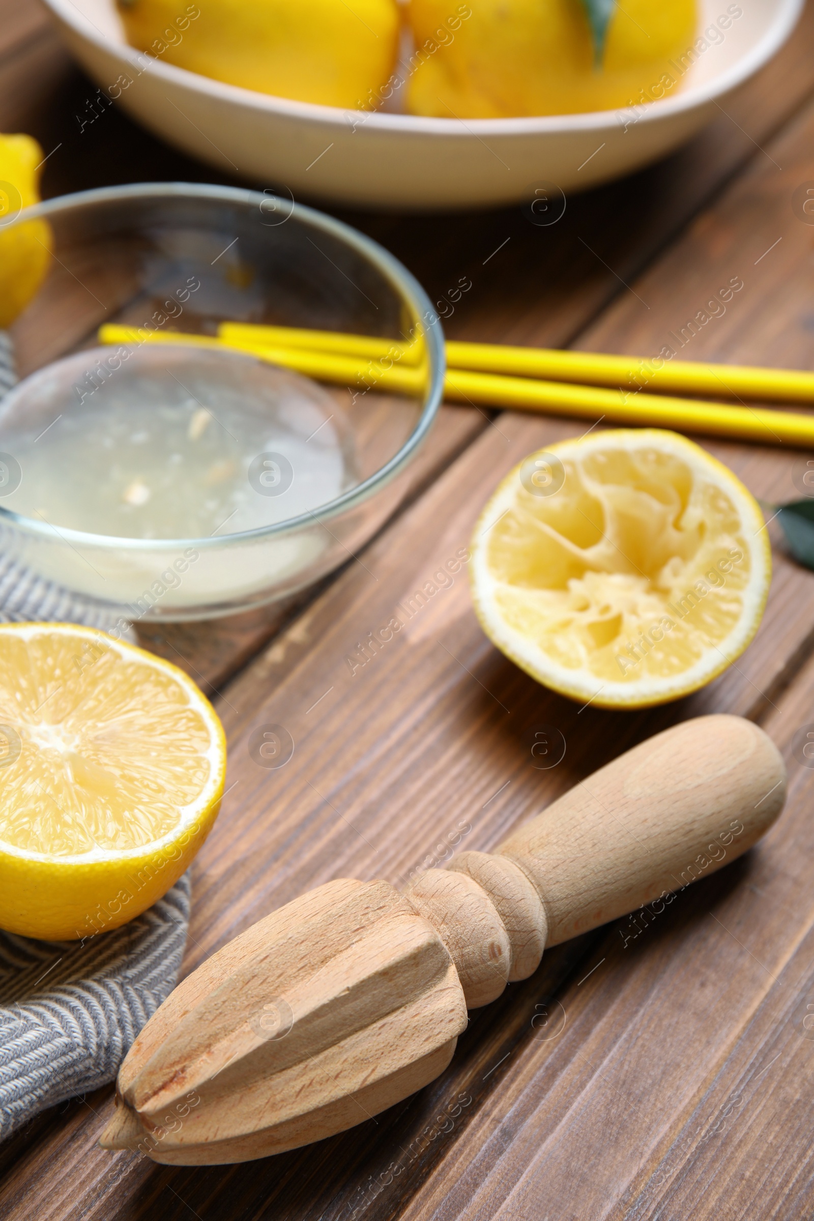 Photo of Citrus reamer and fresh lemons on wooden table