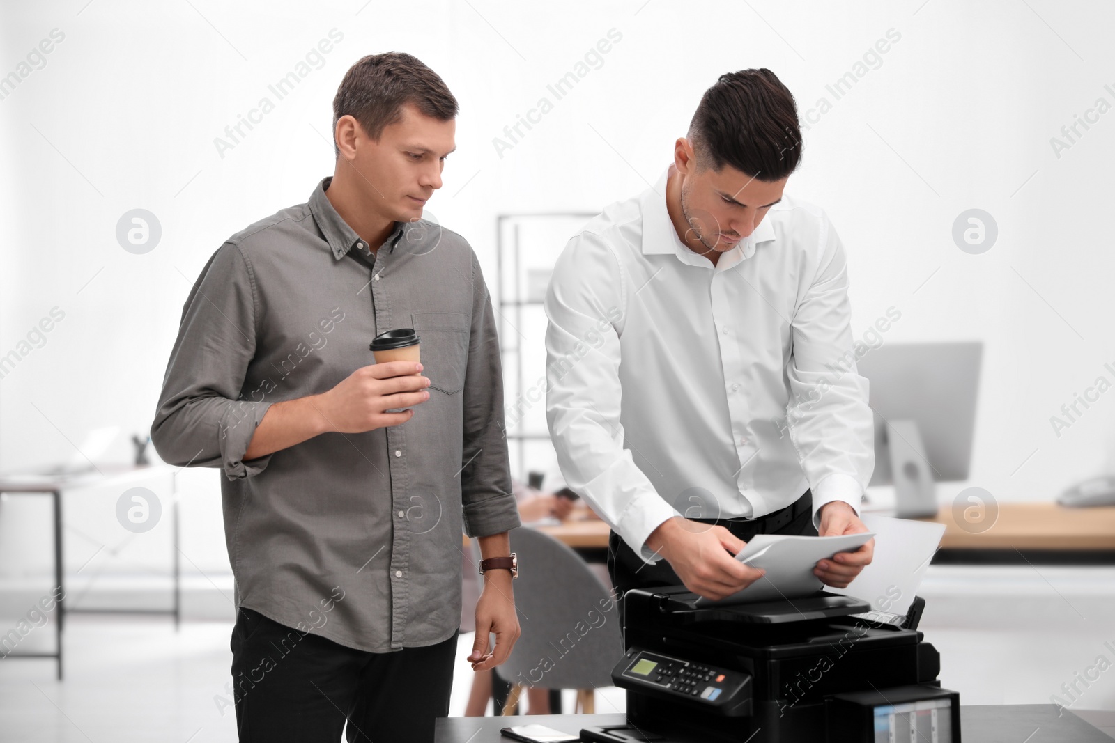 Photo of Employees using new modern printer in office