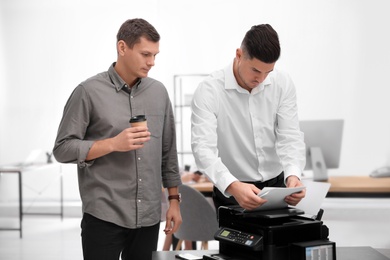 Photo of Employees using new modern printer in office