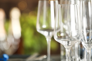 Photo of Empty glasses on blurred background, closeup. Space for text