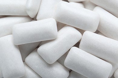 Photo of Tasty white chewing gums as background, top view