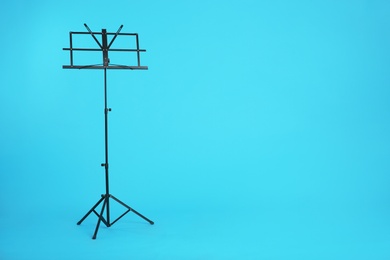 Photo of Empty music note stand on color background. Space for text