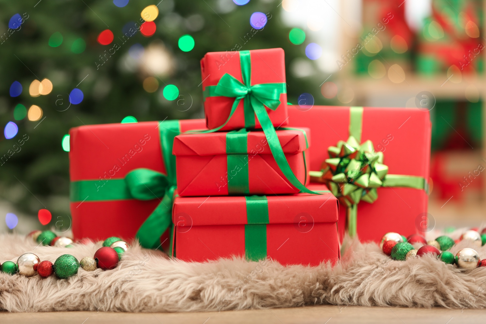 Photo of Christmas gifts on fuzzy rug against blurred background