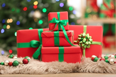 Christmas gifts on fuzzy rug against blurred background