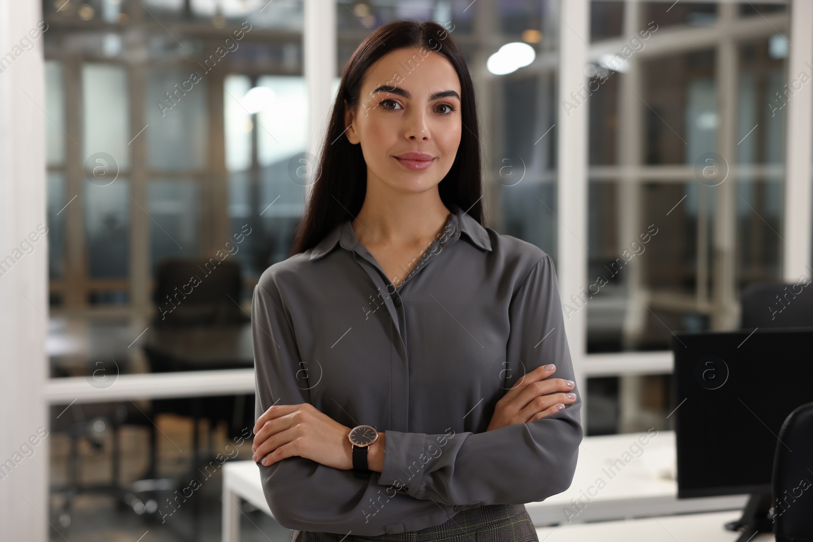 Photo of Beautiful woman with crossed arms in office. Lawyer, businesswoman, accountant or manager