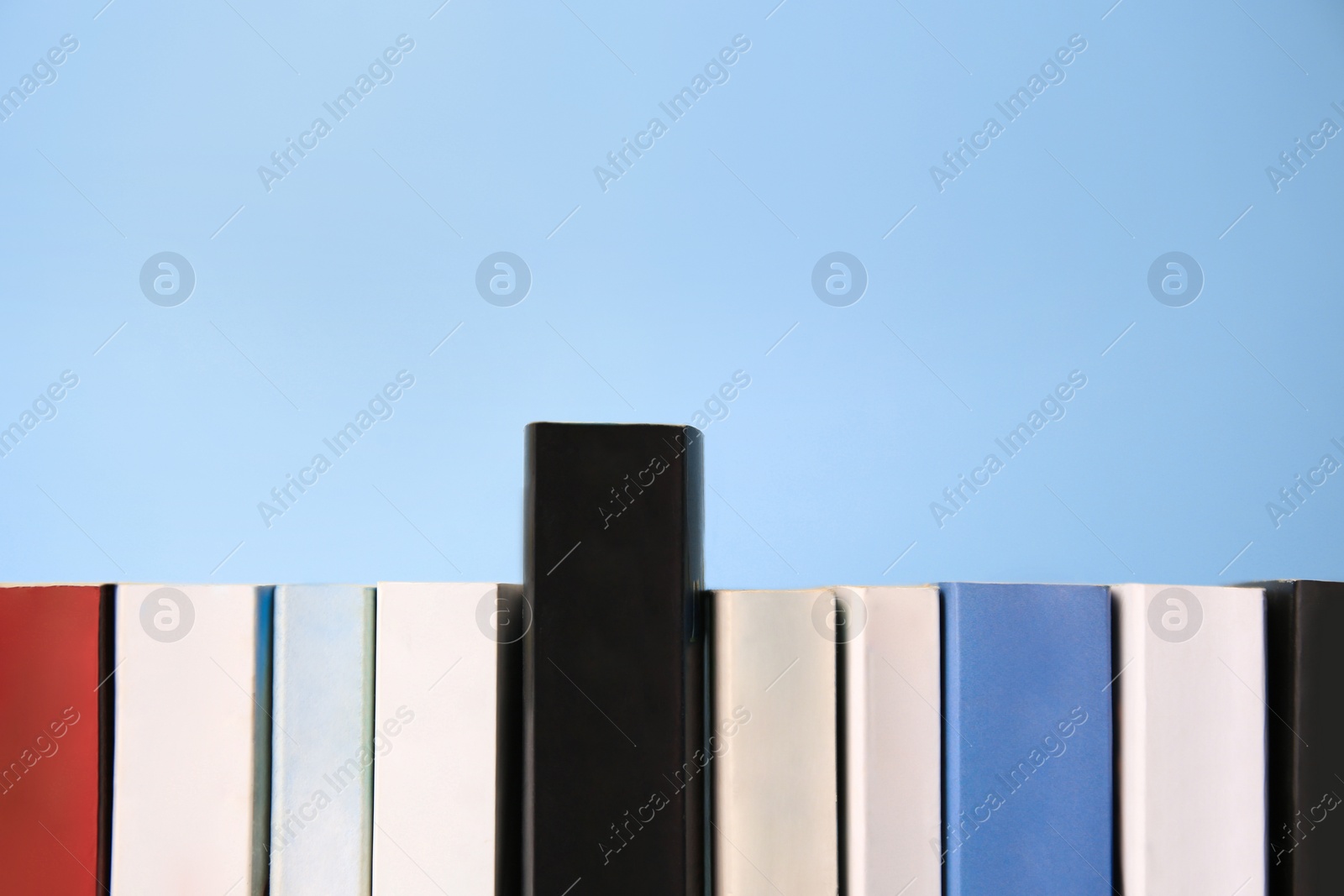 Photo of Collection of books on light blue background, space for text