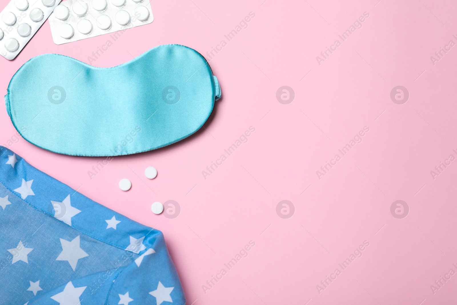 Photo of Flat lay composition with sleeping mask on pink background, space for text. Bedtime accessories