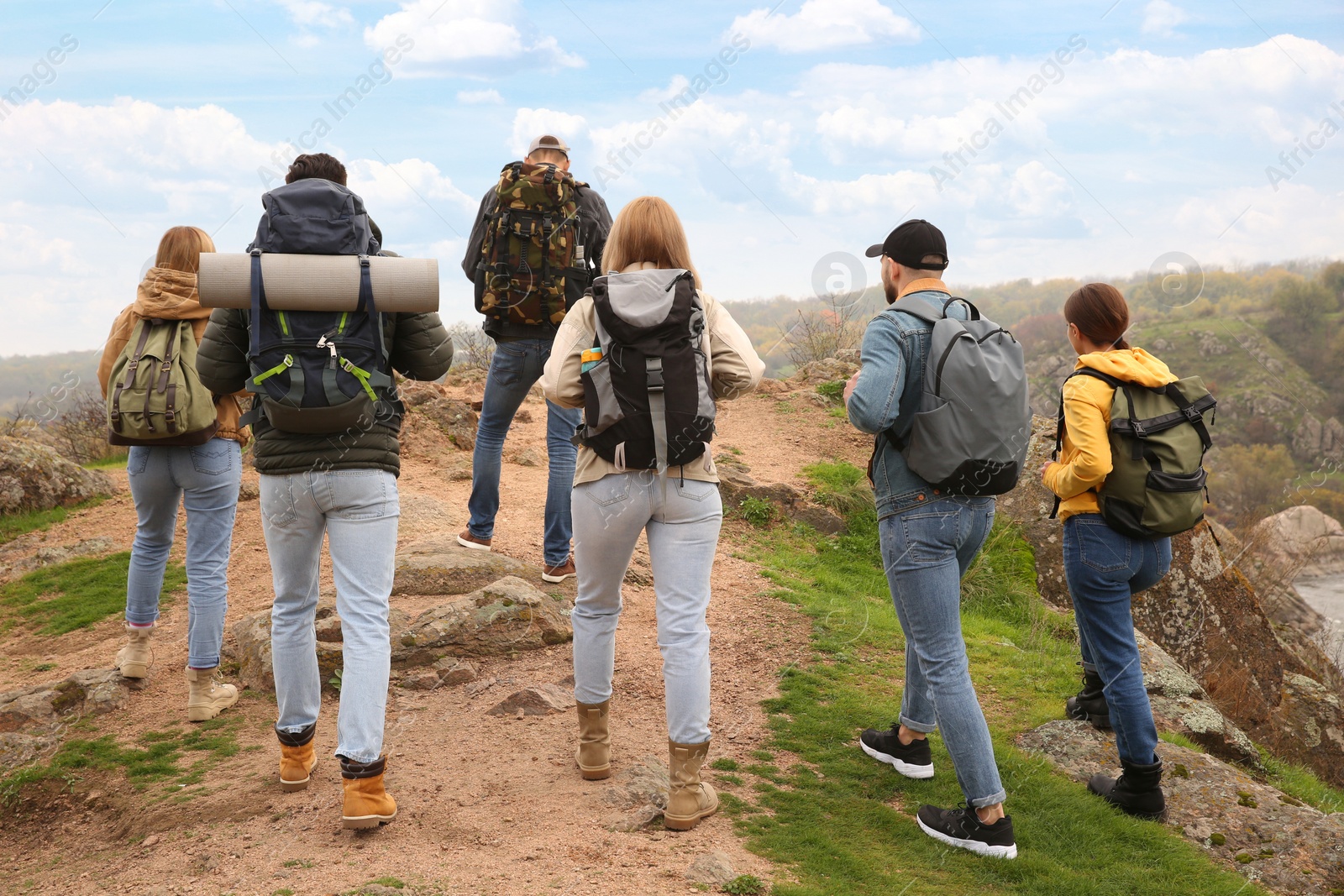 Photo of Group of hikers with backpacks climbing up mountains