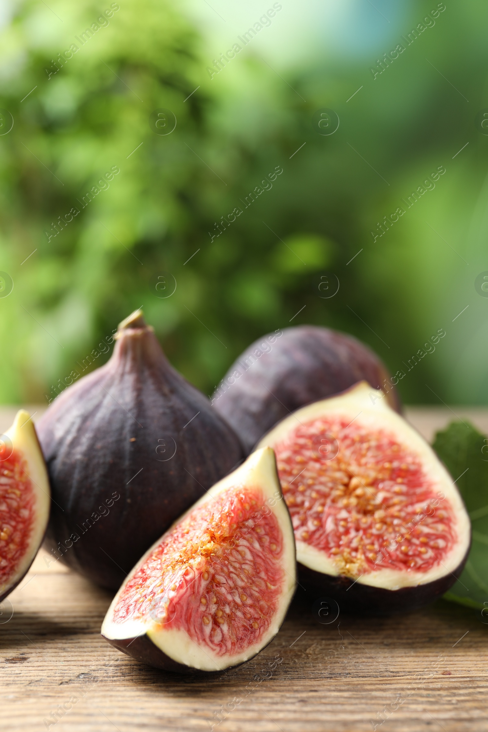 Photo of Fresh ripe figs on wooden table. Space for text